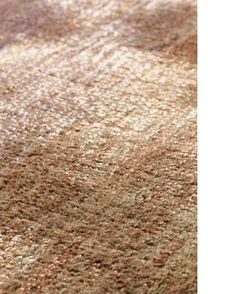 an area rug with brown and beige colors on it, including the carpeting material