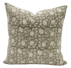 a green and white pillow with an intricate design on the front, sitting against a white background