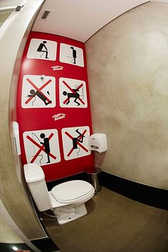 the bathroom is decorated in red and white with stickers on the wall above the toilet