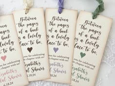 four bookmarks with handwritten bible verses hanging from strings on a lace doily