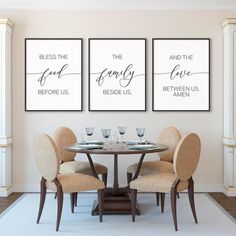 a dining room table with four chairs and two framed pictures on the wall above it