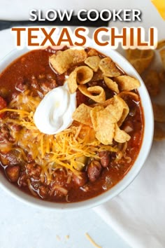 a white bowl filled with chili and tortilla chips on top of a table