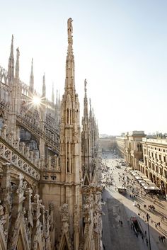 an aerial view of a cathedral with many spires and people walking on the street