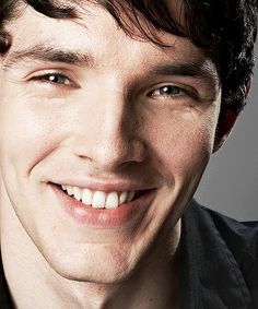 a young man smiling and wearing a black shirt