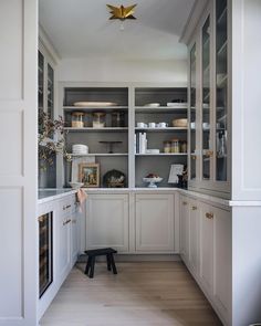 a kitchen with white cabinets and wooden floors