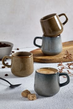 three coffee mugs sitting on top of a table