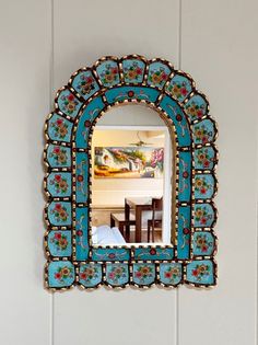 a blue mirror hanging on the wall above a table with a white plate and bowl