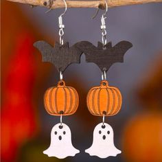 halloween earrings with bats and pumpkins hanging from them