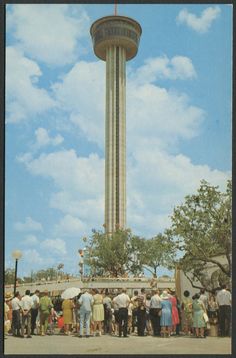 a group of people standing in front of a tall tower