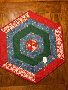 a quilted hexagonal piece on top of a wooden floor