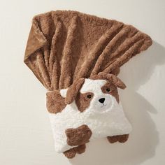 a brown and white stuffed animal hanging on the wall