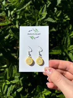 Now available in dangle drop (sterling silver as pictured) or huggies (surgical grade stainless steel).  Welcome to our listing for these delightful handmade mini lemon slice earrings! If you're searching for a splash of freshness and creativity to adorn your ears, these vibrant lemon earrings are just the accessory you've been looking for. Each of these earrings is meticulously crafted by hand, ensuring a one-of-a-kind and charming design that will brighten up any outfit. The intricate workmans Lemon Earrings, Lemon Slice, Unique Charms, Earring Backs, You've Been, Handcrafted Jewelry, Sterling Silver Earrings, Thoughtful Gifts, Jewelry Earrings Dangle