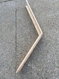 a piece of wood laying on the ground with it's end sticking out from underneath