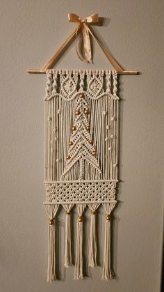 a white wall hanging with tassels and beads