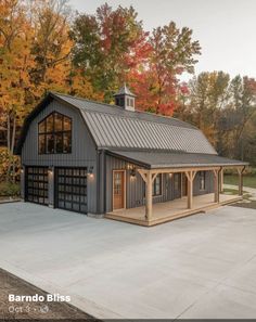 a garage with an attached carport in the middle of a driveway surrounded by trees