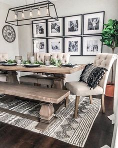 a dining room table and chairs with pictures on the wall above it, along with an area rug