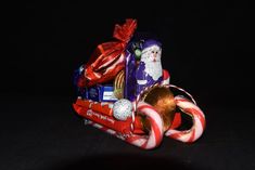 an assortment of candy and candies on a sleigh with santa claus in the background