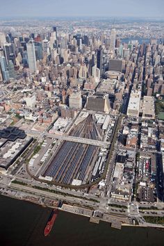 an aerial view of a city with lots of tall buildings and train tracks in the foreground