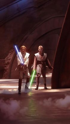 two people standing next to each other in front of a star wars scene with lights on