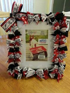 an old photo frame decorated with red and white ribbons