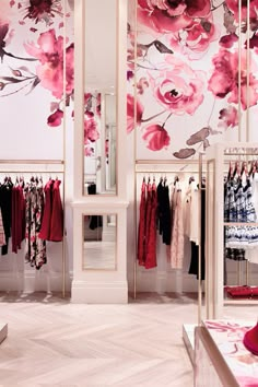 the inside of a women's clothing store with floral wallpaper