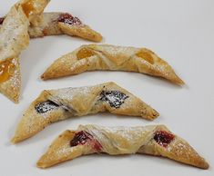 four pieces of fruit filled pastries on a white surface