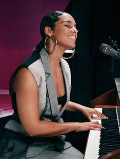 a woman sitting at a piano smiling