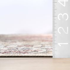 a ruler is on the floor next to a rug