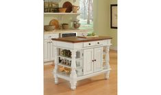 a white kitchen island with wooden top in a room