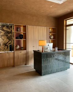 an office with marble counter tops and wooden cabinets in front of a large glass window