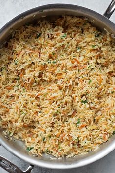 a pan filled with rice and vegetables on top of a table