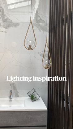 a white sink sitting next to a wooden wall with hanging lights on it's side