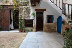 an outdoor area with stairs and potted plants on the side of the building that has blue shutters