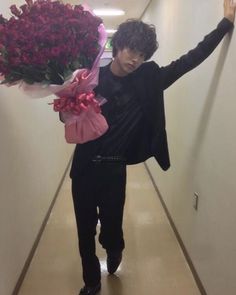 the man is carrying flowers down the hallway