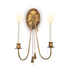 a wall mounted light with two candles on each side and an angel decoration on the back