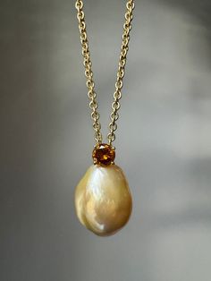 "At 14 years old, Henry Dunay embarked on his jewelry odyssey by apprenticing under New York jeweler Rudolf Cassioli. Dunay evolved into an exceptional goldsmith, gaining renown for his groundbreaking artistry and inventive techniques. A large golden cultured pearl is beautifully balanced by a .60 carat fancy deep brownish orange diamond mounted on a 20 1/4\" cable link chain. This pendant is accompanied by a GIA Pearl Identification Report stating: semi-baroque, bead cultured saltwater pearl, orient overtone. Pearl: 15 mm wide, only width can be measured accurately due to gold backing Diamond: estimated .60 ct, I1 clarity, fancy deep brownish orange  Pendant measurements: 24.75 x 15 x 15.56 mm Weight: 22.4 gramsMarkings: Dunay, 18K, A63655, D5065 GIA report: 2225988917" Pendent Gold Design, Pendent Gold, Orange Diamond, Pendant Ideas, Golden Pearl, Saltwater Pearls, Fancy Diamonds, Pearl Pendant Necklace, Gold Design