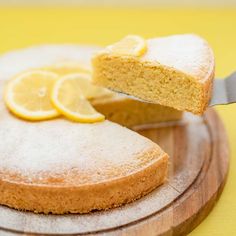 a slice of lemon cake on a wooden plate with a knife