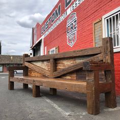 a wooden bench sitting in front of a red brick building