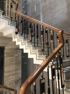 a stair case with metal handrails and wood balustiers in a building