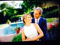 a man and woman standing next to each other in front of a pool