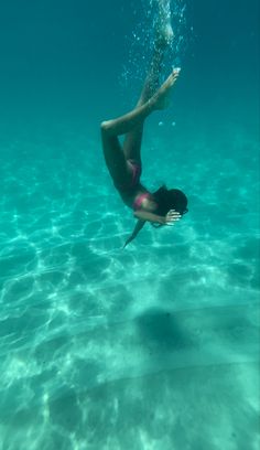 a woman is diving in the water with her feet above the water's surface