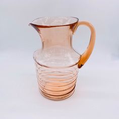 a glass pitcher with a wooden handle is stacked on top of each other in front of a white background