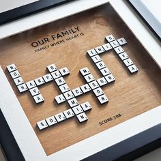 a family scrabbled crossword puzzle in a black frame on a table