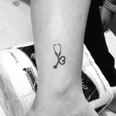 a black and white photo of a person's foot with a stethoscope tattoo on it