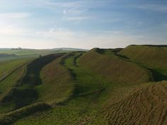 an aerial view of green hills and rolling grass on a sunny day in the countryside