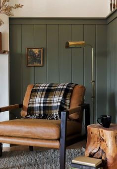 a living room filled with furniture and a fire place in front of a green wall