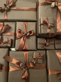 many wrapped presents with bows and pine cones