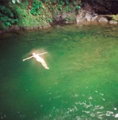 a person floating in the water with their arms out