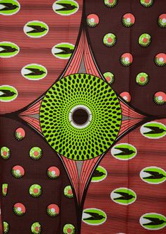 an abstract design with green and pink circles on red fabric, as well as black dots