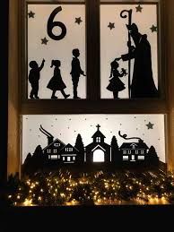 the silhouettes of people and children are displayed in front of a window with christmas lights